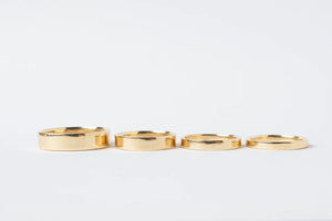 Row of custom, flat ring bands in 18k gold by Truss and Ore