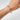 Hand modeling gold bangle with 10 square emeralds bezel set and attached to jump rings around the bracelet