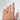 Hand modeling gold ring with two interlocking open hearts