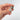 Hand holding silver clam shell charm with pearl