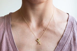 Woman modeling handmade, asymmetric 18k gold Lietuva necklace by Truss and Ore