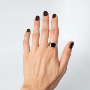 Hand modeling vintage 14k gold signet ring with black onyx